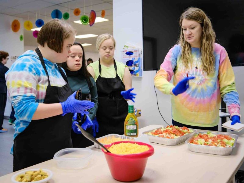 Program leader for GiGi's Kitchen gives directions to participants to prepare food and teach the importance of health and wellness