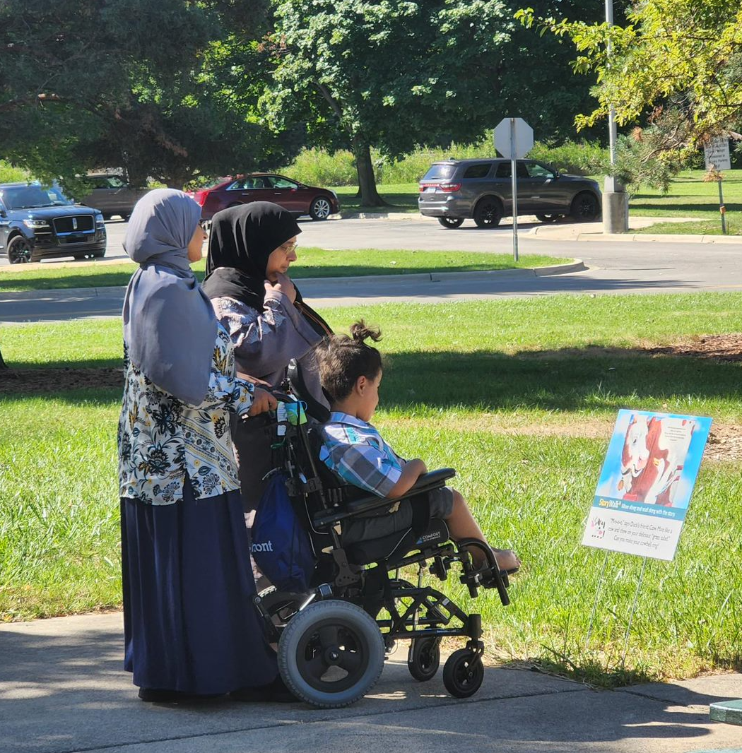 A family enjoys a StoryWalk®.