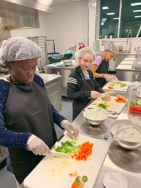 Students chop vegetables.