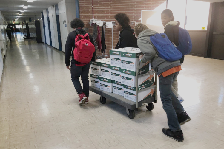 Scott Middle School students push a delivery of supplies gifted through the Flint Classroom Supply Fund through the newly reopened school.