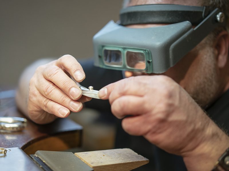 Flint, MI - Tuesday, May 8, 2018: Flint resident and metalsmith Robert McAdow inspects a setting in a pendant he is creating.
