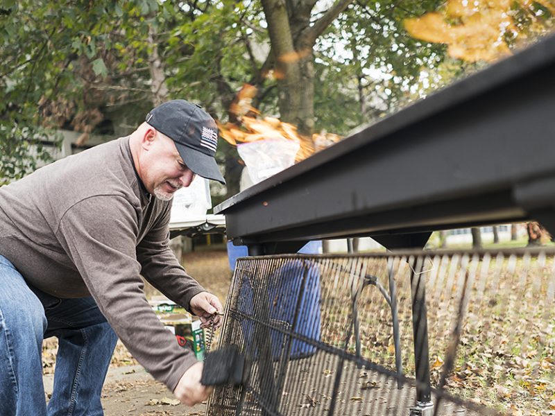 Steven Moore, 52, of Davison cleans the grate of the large grill at the Flint Community Cookout at the Riverbank Park. Moore, a retired police officer, enjoys being able to connect with the community in a positive way, which wasn't always the case wh