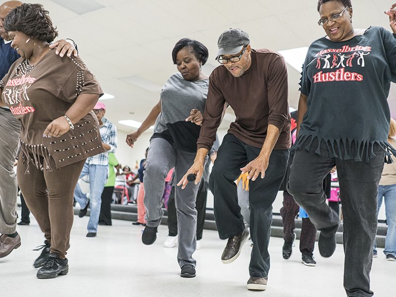 Gardell Haralson, 64, of Flint (center right) takes a break from emceeing to dance with the Hustlers at the Hasselbring Senior Community Center. "It gave me the feeling I was doing something," he said about the progress of the Hustlers. "They're not