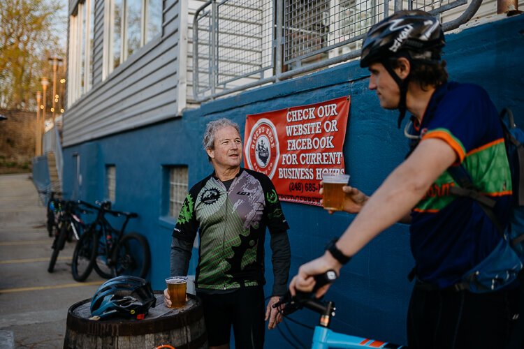 Bill Hermann and Rob Morris return from their bi-weekly ride with the Spoke Junkies cycling club and stop at Rivers Edge Brewing Company in Milford.