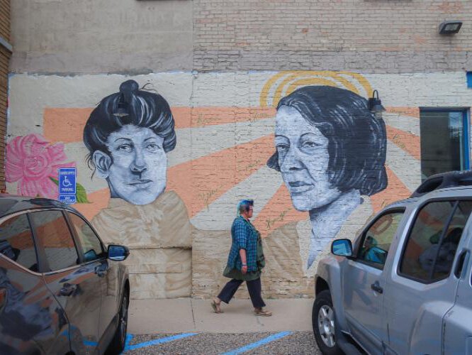 Jenn Schaub walks along the Beverly Sisters mural by Jamari Taylor. The Heartside Historic Murals series is one of the many examples of the neighborhood's artistry.