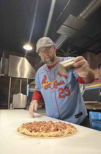Jeremey seasons one of Archie's signature St. Louis-style pizzas.