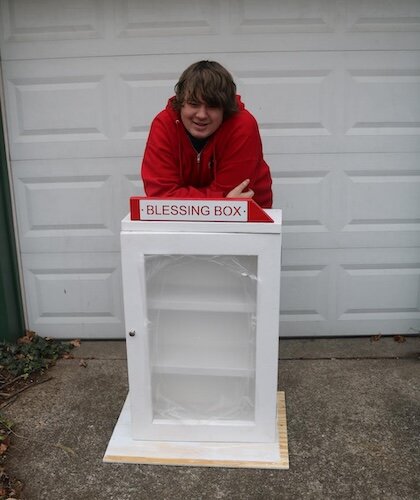 Kyle Werner stands with one of the blessing boxes he built.