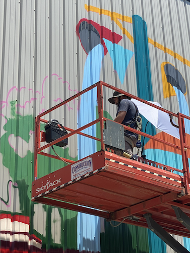 Brennan paints a section of the mural on June 13.