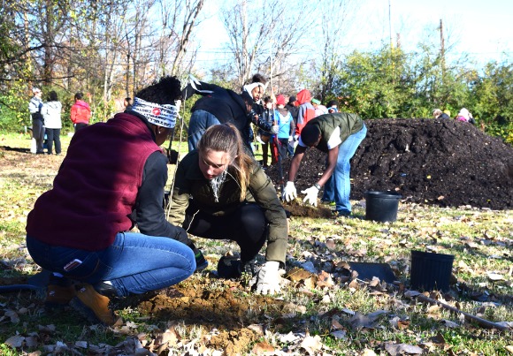 Bridge Builder Madison (L) and partner Sadie (R) plant trees in a Medical District lot. Mahal Burr, Bridge Builders' CHANGE coordinator, says tree planting is an opportunity for their youth to learn about environmental justice and the importance of green infrastructure.   (Cole Bradley)