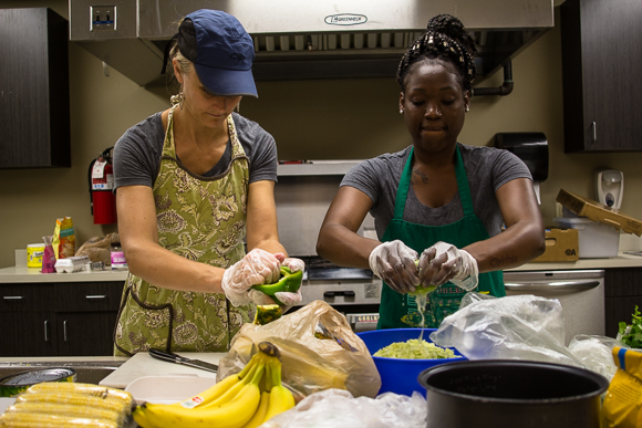 Kristin Fox-Trautman and Charlena Branch working with food at Kaleidoscope Kitchen in Binghampton.