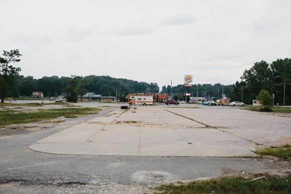 Formerly home to the Treasury, the lot in Frayser now sits vacant and overgrown, with vehicles scarcely parked about.