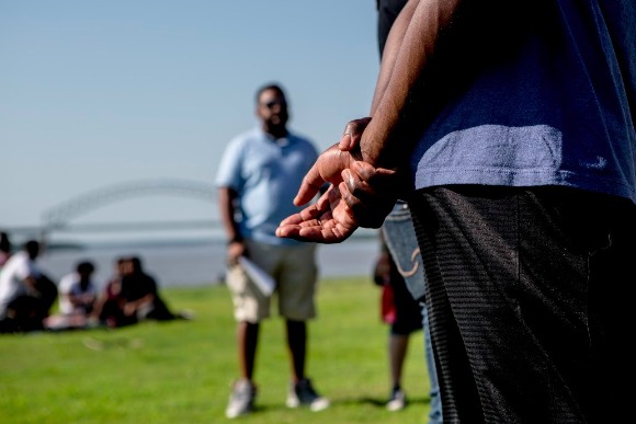 Greg Woodberry, a member of the Official Black Lives Matter Memphis, clasps his hands behind his back while performing an adapted rap during the Bridge Shut Down reunion at Tom Lee Park.