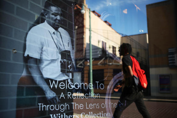 A Beale Street visitor is reflected in the window of the Withers Collection Museum & Gallery.