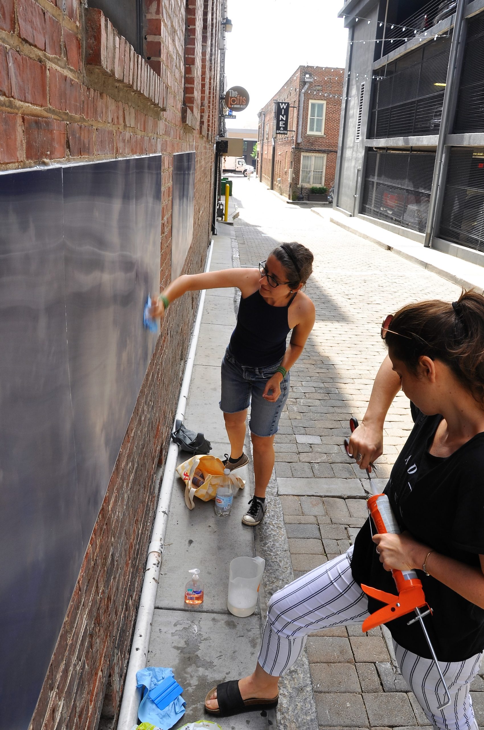 Eszter Sziksz (R) and Stephanie Cosby (L) work on "Skywalker", an art installation in Barboro Alley.