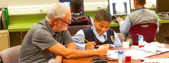Volunteer and Streets board member Drew Gibson tutors Quentin Vazquez, a 6th grader at Grizzlies Prep Academy. 