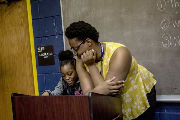Aleigha Hall, a librarian at Cornelia Crenshaw, talks with Jernya, 11, during an event for Mother’s Day.