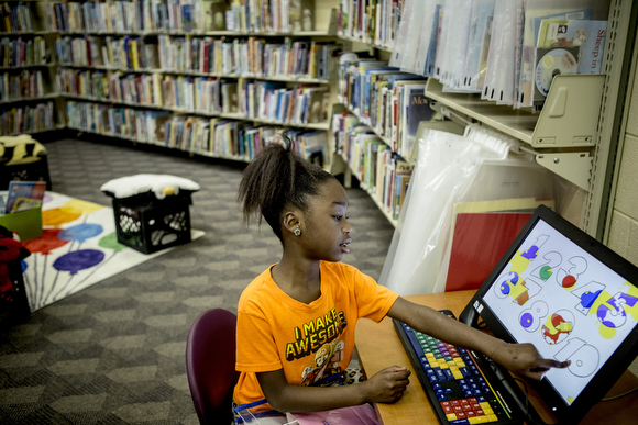 Janiya, 8, uses one of the computers in the kids’ corner at the Cornelia Crenshaw Library.