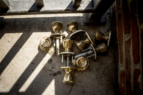 A collection of doorknobs sits on one of the porches of a boarded up building at Foote Homes.