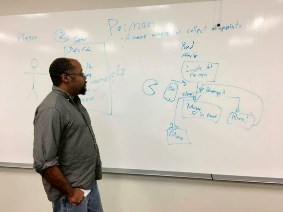 Devitt Upkins, founder of Memphis Game Developers, explaining Pac-Man ghost patterns via flowchart at a Memphis Game Developers design workshop.