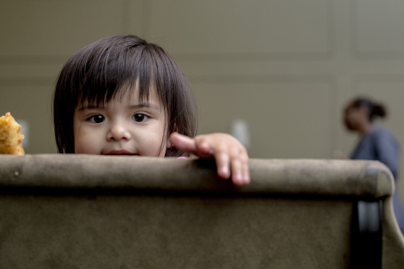 Azaylia Elias, 1, peeks out over a chair at the Operation Smart Child program at the Neighborhood Christian Center in Smokey City. (Andrea Morales)