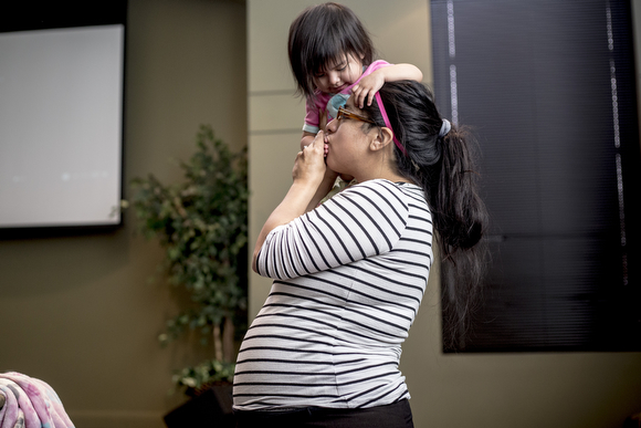 Thressia Elias kisses her daughter, Azaylia Elias, 1, during Operation Smart Child, a prenatal program for expectant mothers, at the Neighborhood Christian Center.