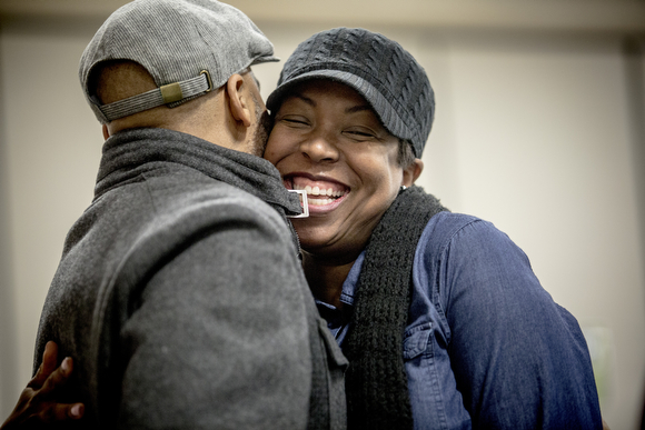Angela Adair hugs her husband Robert during Sunday service at Hope City Church in Caldwell-Guthrie's cafeteria in Smokey City.