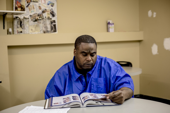 Kenny Young studies his book in one of the classrooms at The Barber School on Jackson Avenue in Klondike.