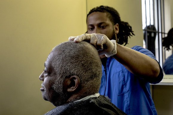 Torin Marshall gives Bill Candely a haircut at The Barber School on Jackson Avenue in Klondike.