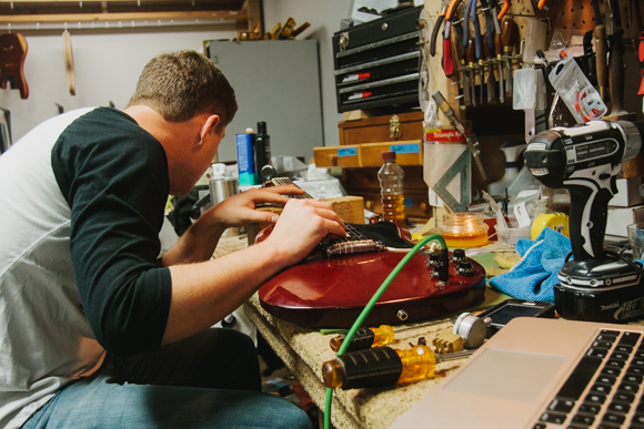 Hans Hilboldt installing strings on an electric guitar.