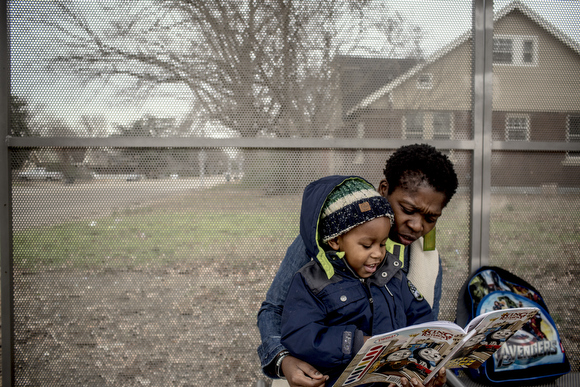  Shelia Williams and her son Tailor Jackson, 3, read a book together while at a bus stop.