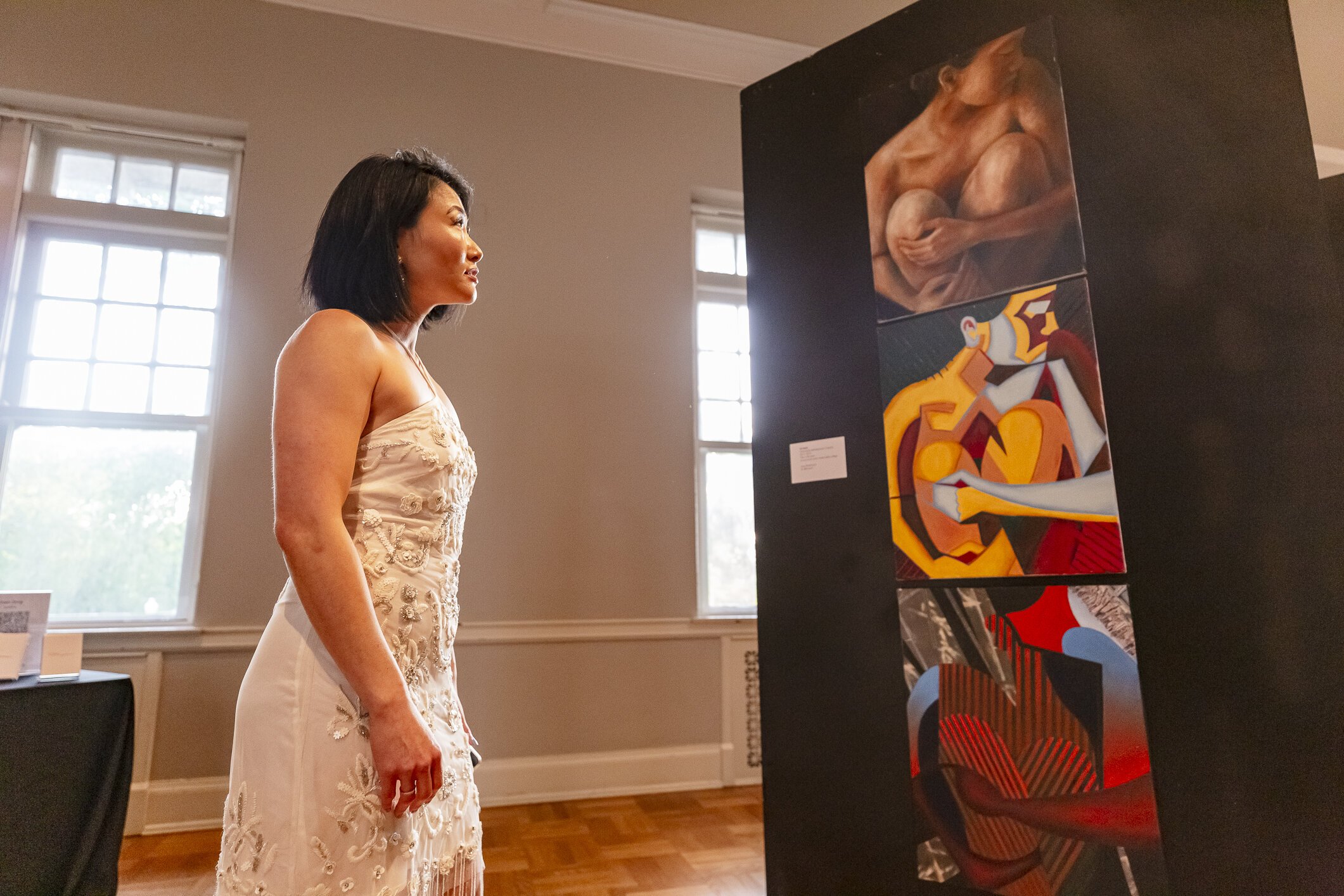 Dr. SunAh Laybourn takes in LiLi Nacht's "Vulnerability" at the Asian American in the South art exhibition at the Museum of Science and History on Thursday, May 18. (Photo by Ziggy Mack / Courtesy of Dr. SunAh Laybourn)