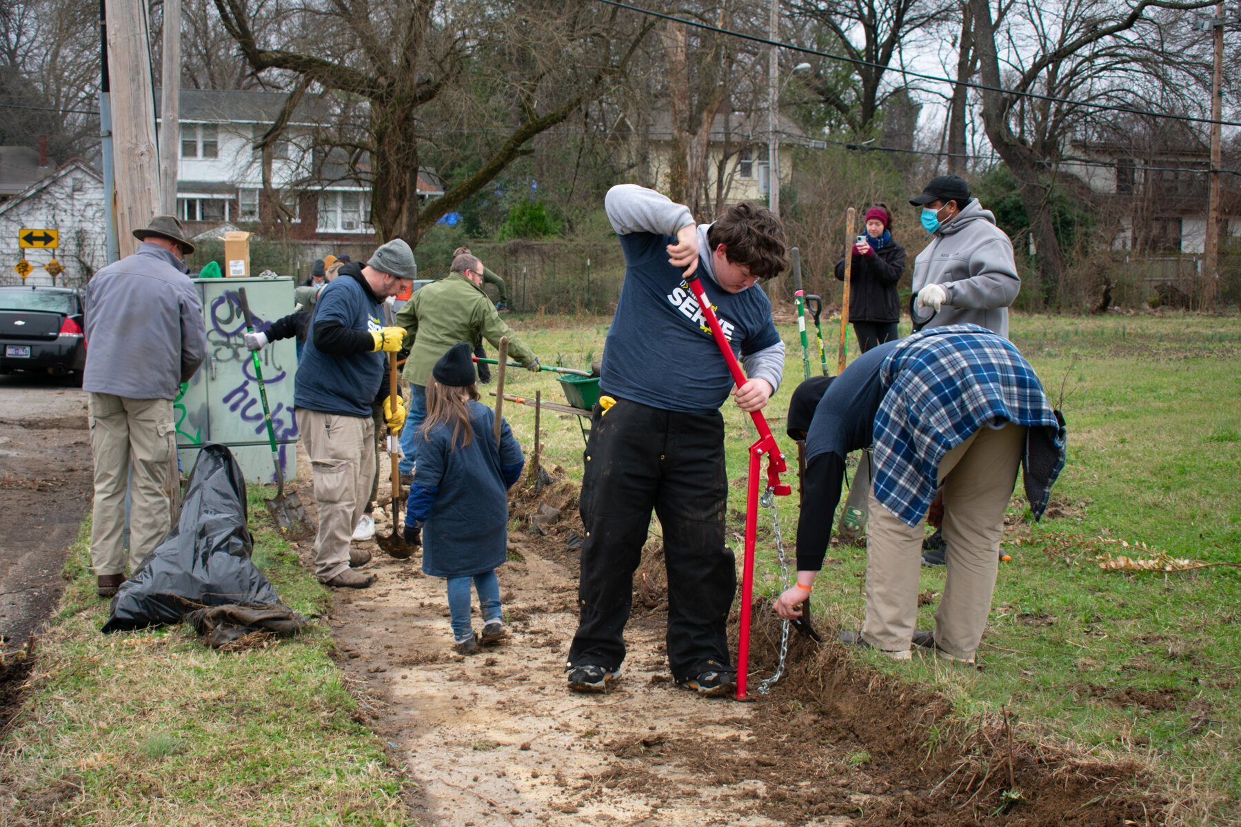 Volunteers with The Works CDC work together to clear a sidewalk along Jefferson Ave. (Sarah Rushakoff)