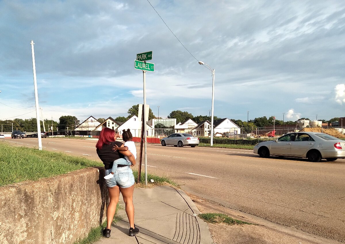 Sterling Key stands opposite the new Porter-Leath and U of M early childhood center in Orange Mound. She points and talks about the development with two-year-old daughter, Amirah. (Alexandria Moore)