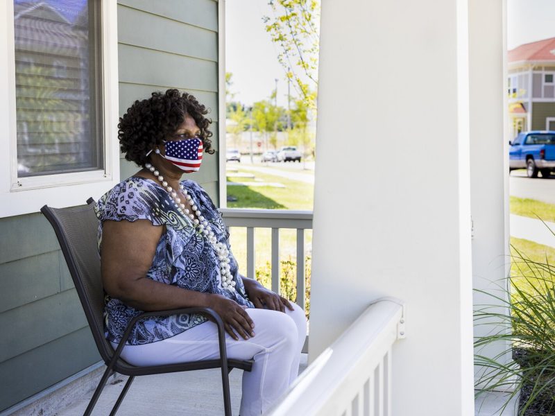 Denise Oher sits on a neighbor's porch and looks out over the new Foote Park at South City development. Oher is a former Foote Homes resident who has chosen to return after being displaced for the demolition of Foote Homes. (Ziggy Mack)