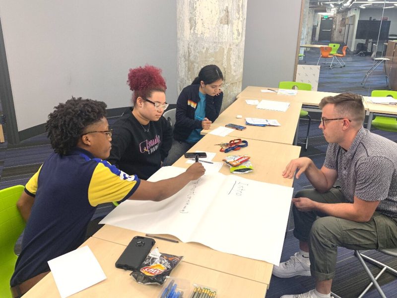 Members of the LITE Memphis Finalist Program (left) work on their business plan with the help of a volunteer (right). (LITE Memphis)
