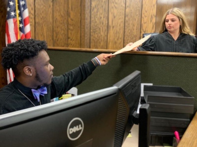 Community Court Clerk Darious Scott (L) hands a case file to Community Court Referee Lisa Harris, who will preside over the case. Community Court is a subsidiary of Shelby County Environmental Court. (Rob Brown)