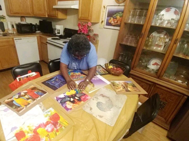 Derotha Payne-Obie mounts a recently completed puzzle at her dining room table. Prior to the pandemic, she attended the Lewis Senior Center. It closed in March under local and state mandates. (Tamara Cunningham)