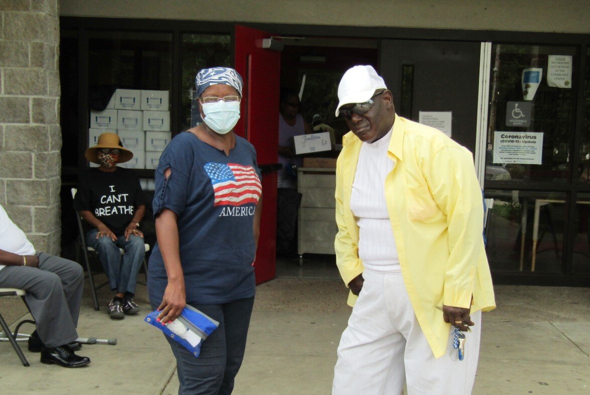 Dorothy Johnson and Frank Robinson pose for a photo at Bickford Community Center on a MIFA food relief box pickup day. The Oasis of Hope senior program, housed in the center, closed in March when the novel coronavirus pandemic hit Memphis. Boxes of food can be seen stacked inside the build to the left. (Tamara Cunningham)