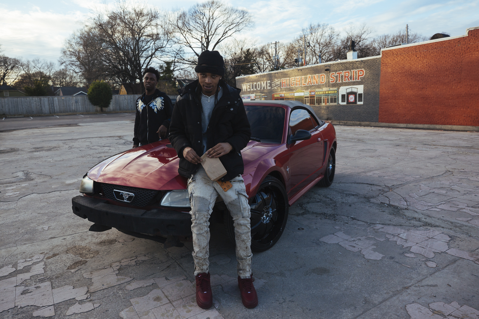Two young men hang out in a parking lot of at the end of the Highland Strip, 2019. (Ziggy Mack)