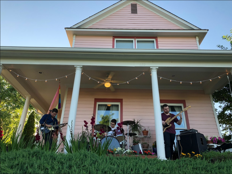 Uptown neighbors listen to Memphis-based Geist at the first Uptown porch concert series. The house is typical of the style and bright colors of many Uptown homes, 2019. (Cole Bradley)