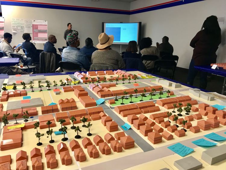 Residents and other stakeholders hear the results of the three-day design charrette to reimagine Whitehaven Plaza. In the foreground, the model of Whitehaven Plaza, 2019. (Cole Bradley)