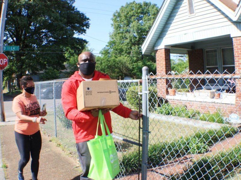 JUICE Orange Mound board members Kenya Holmes (L) and Broderick Conneser deliver supplies to a senior in Orange Mound. JUICE asked residents to text what supplies they needed and personalized orders before delivery via CAREavan. (Cole Bradley)