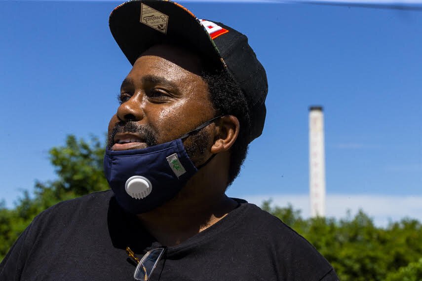 Environmental activities and community organizer Frank Johnson stands in the Smokey City neighborhood of North Memphis. Behind him looms the iconic smokestack of the now-defunct Firestone plant. The neighborhood takes its name from the smoke that rose from the stack decades ago. (Ziggy Mack)