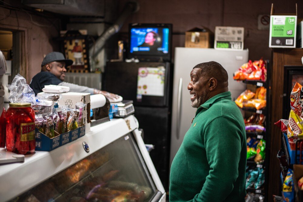 Rufus Sykes (left), co-owner of South Memphis Grocery, keeps a customer laughing with old stories while he waits on his order. (Malik Martin)