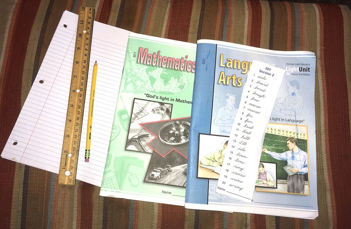 Hunter Coleman's homeschool workbooks sit beside him as he works on other tasks. Workbooks are a good resource to enhance the core curriculum with extra practice time. Completing workbook pages are good tool for helping kids earning special rewards. (Jim Coleman)