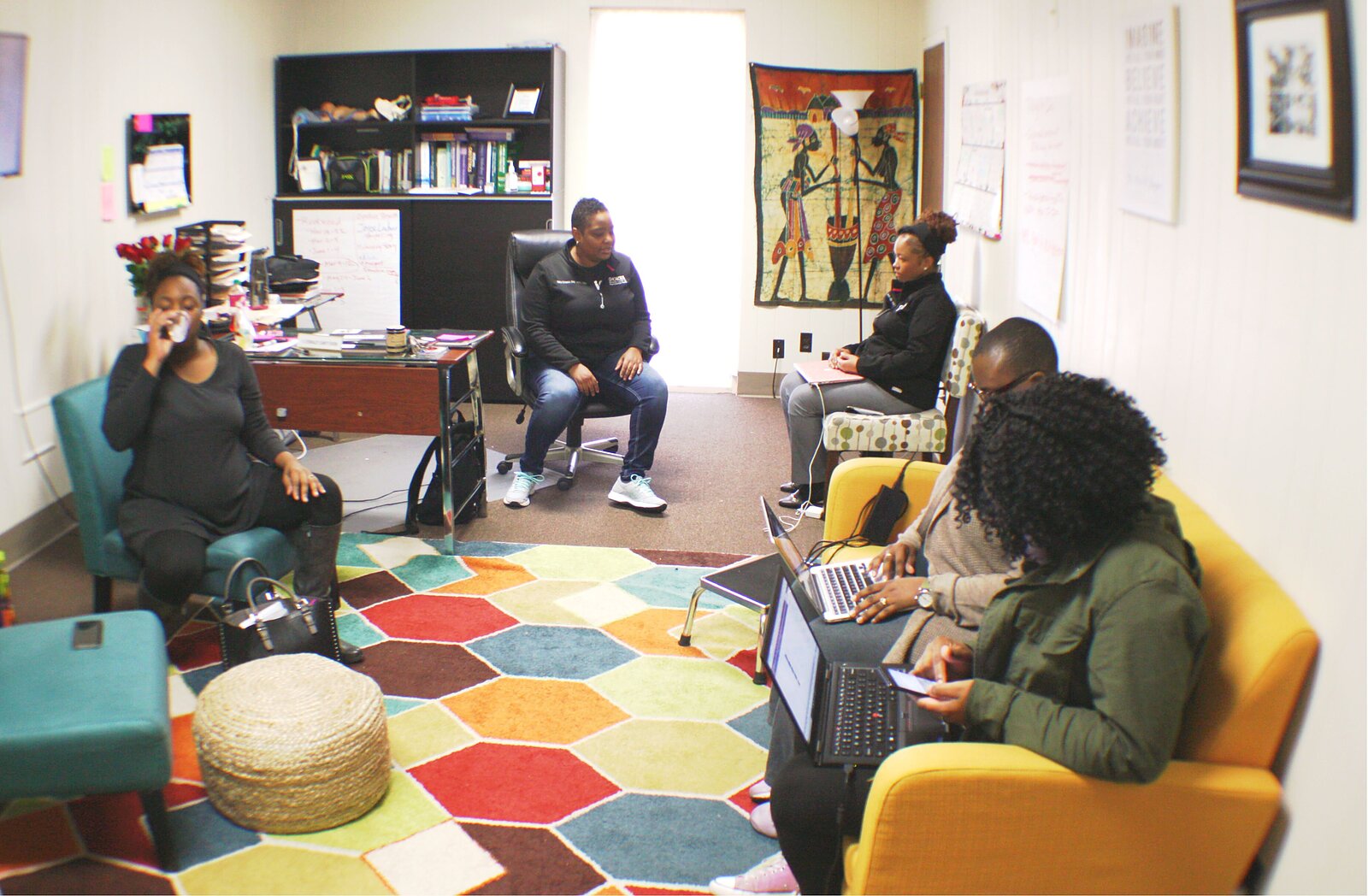 A gathering in Nikia Grayson's office at the CHOICES midwifery center shows the changing landscape of midwifery care in Memphis, which has been dominated by white practitioners since the 1960s. L to R: patient Michelle Green; CNM and Director of Midwifery Nikia Grayson, CNM Kemetra King, student midwife Terri Lee-Johnson, and Alexius Hill, who is both Grayson's assistant and a birth doula. (Cole Bradley)