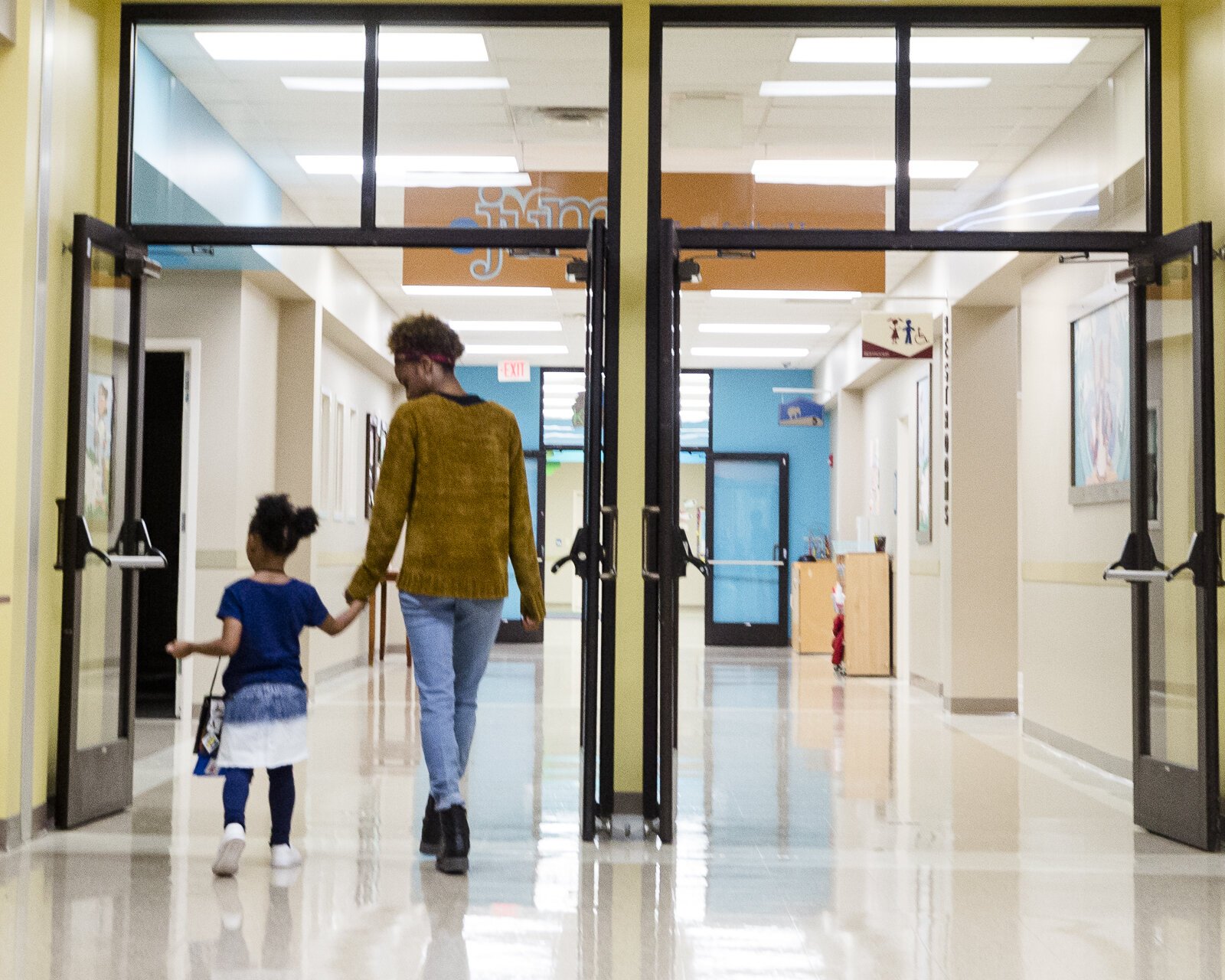 Amon Dillan walks holds hands with a Harwood Center student was they walk down the hall of their Cordova location inside Hope Church. January 27, 2020. (ZIggy Mack) 