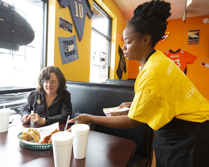 Justina Bell delivers hot wings hot from the kitchen of Mike's Wings & Such in Hickory Hill. High Ground's Emily Trenholm (pictured) was especially exited to try the spicy seasoned wing. (Ziggy Mack)