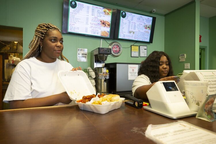The staff at The Chicken Coop in Hickory Hill show finished orders to satisfied patrons and cash them out. (Ziggy Mack)