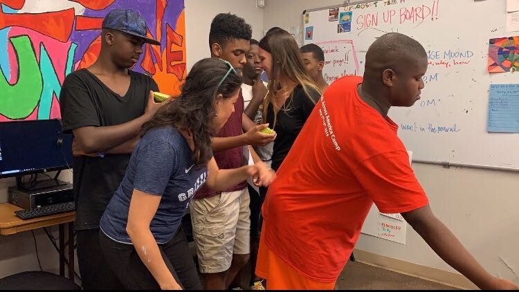 Yancy Villa-Calvo (front row, left) and the teens of RedZone Ministries line up to make notes on a draft of the mural they're installing on the Whitten Brothers Hardware Store in Orange Mound. (Yancy Villa-Calvo)
